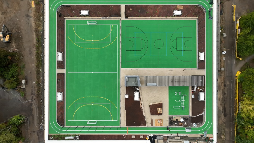Vogelperspektive auf die fertigen Sportfelder auf dem Dach der Sporthalle